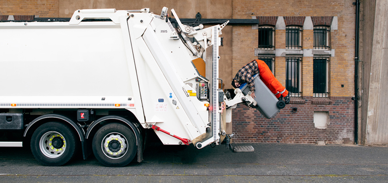 Chauffeur knuffelt container van MKB-afval service om van te houden campagne