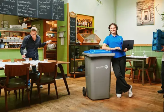 Klantenservice medewerker met 360 liter rolcontainer in Horecazaak